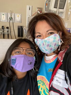 Neuromyelitis News | Bella and Candice pose for a selfie in the hospital early on in the pandemic. Both are wearing colorful masks