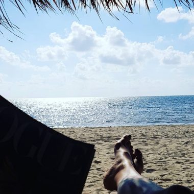 air travel and NMO | Neuromyelitis News | A view of the ocean in Mexico from a beach bed. Jennifer's feet are visible as she relaxes in the shade.