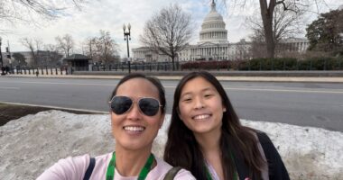 A mother and daughter take a selfie together in Washington, D.C., with the U.S. Capitol in the background.