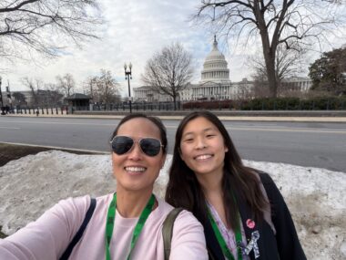 A mother and daughter take a selfie together in Washington, D.C., with the U.S. Capitol in the background.